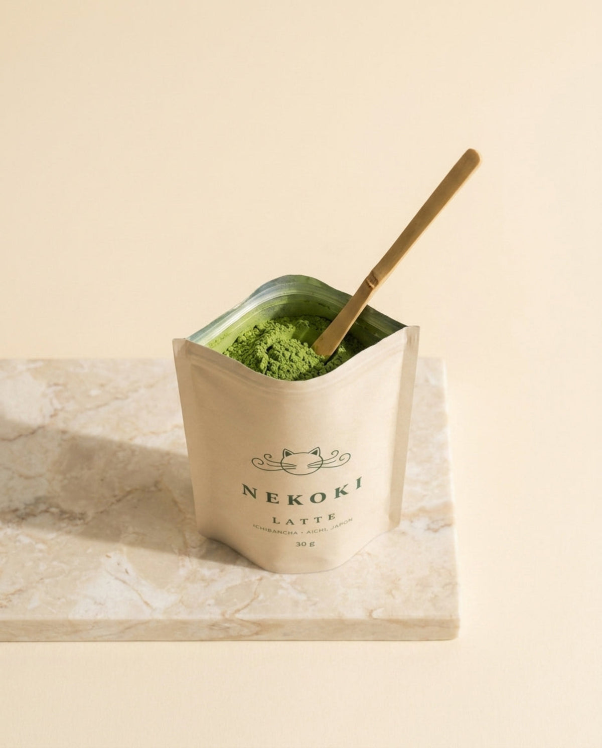 Pochette Matcha Latte ouverte, poudre verte avec cuillère bambou