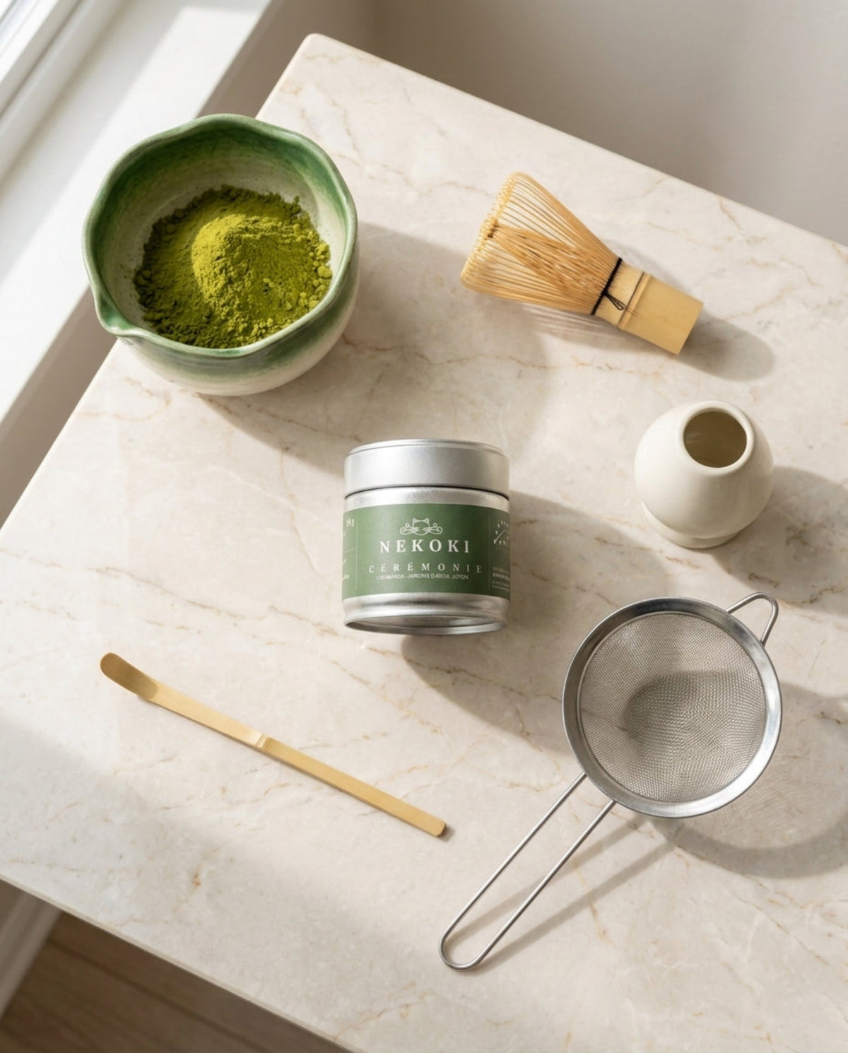 Le Rituel Complet Nekoki, version verte : boîte Matcha Cérémonie bio 30 g avec bol, chasen, chashaku, support et tamis, sur marbre crème